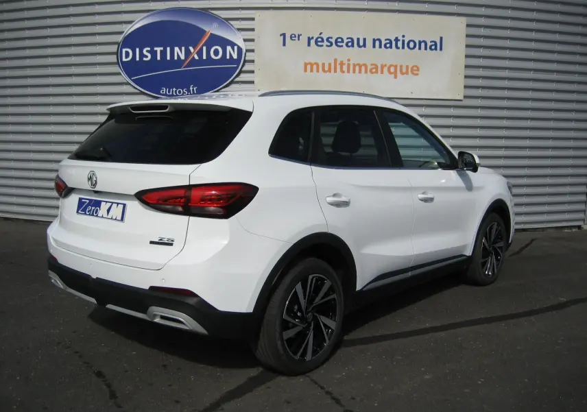 Vue 3/4 arrière droite du SUV blanc MG ZS 1.5 HYBRID+197 LUXURY avec jantes noires et feux arrière LED.