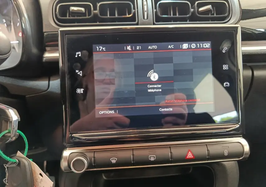 Vue rapprochée de l’écran tactile central noir du tableau de bord de la Citroën C3 blanche, affichant la connexion Bluetooth.