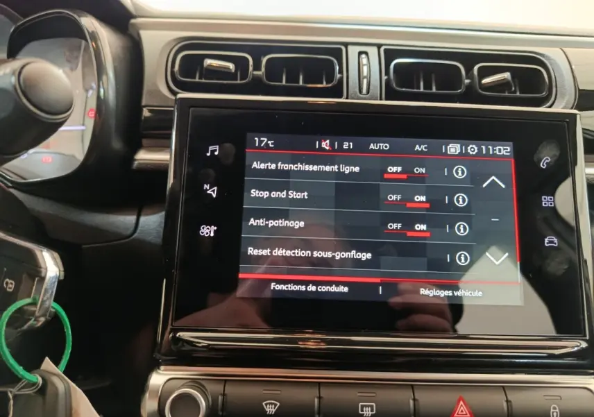 Vue rapprochée de l’écran tactile central de la Citroën C3 blanche 2022 affichant les réglages d’aide à la conduite.