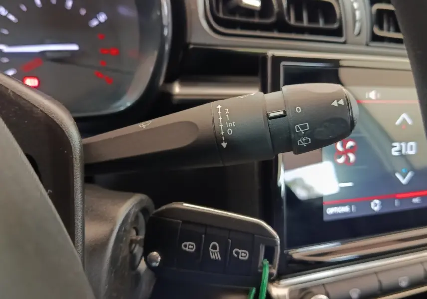 Gros plan sur la commande d'essuie-glace et le tableau de bord tactile de la Citroën C3 blanche, version 2022.