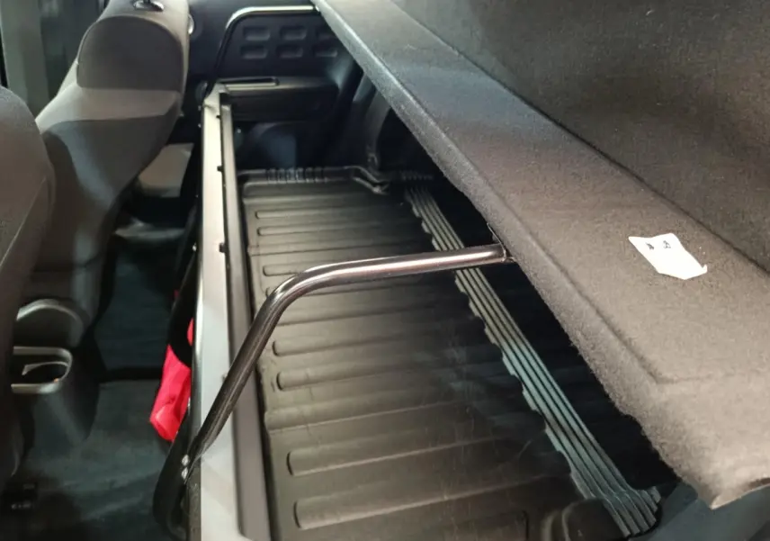 Vue intérieure arrière de la Citroën C3 blanche, montrant le coffre avec tablette de séparation relevée.
