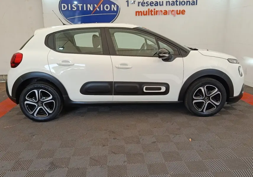 Vue latérale droite d'une Citroën C3 blanche de 2022 avec protections noires et jantes alliage distinctives.