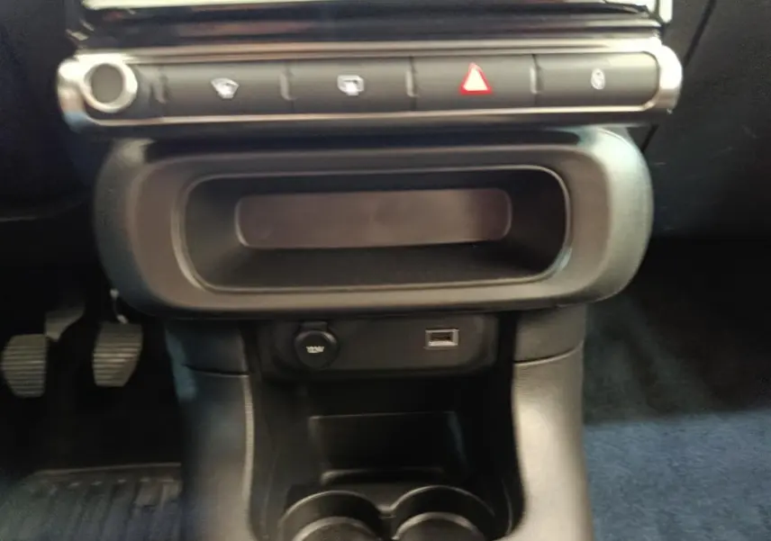 Gros plan sur la console centrale noire de la Citroën C3 2022, avec prise 12V et port USB visibles.