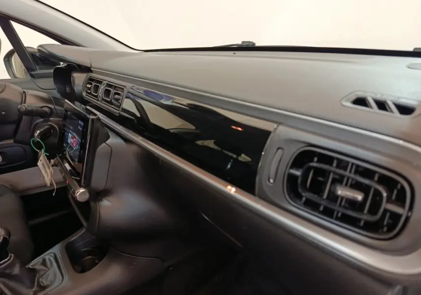 Vue intérieure côté passager du tableau de bord noir brillant et écran tactile de la Citroën C3 PureTech 2022.