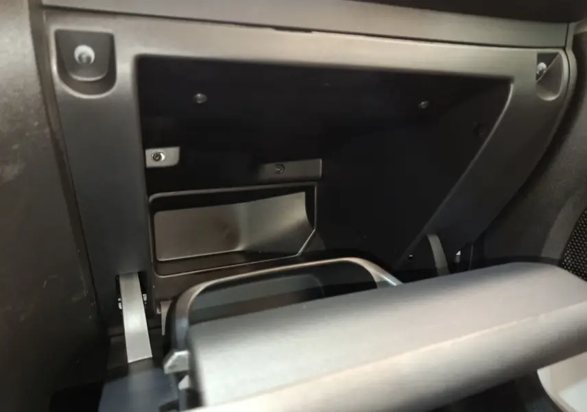 Détail de la boîte à gants réfrigérée ouverte dans l'habitacle noir d'une Citroën C3 blanche, vue de face.