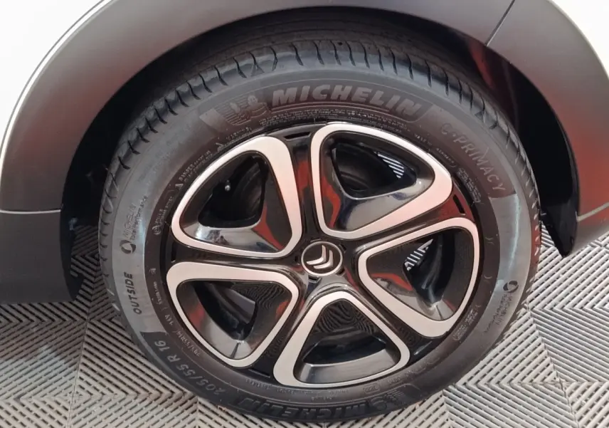 Gros plan sur la roue avant droite de la Citroën C3 blanche, avec jante alliage noire et argentée distinctive.