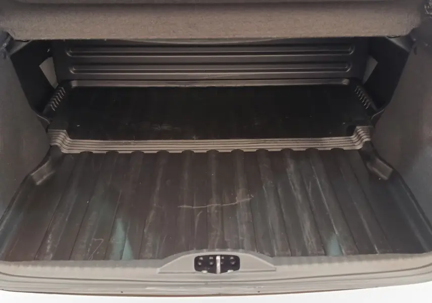 Coffre ouvert vu de face d'une Citroën C3 blanche 2022 avec tapis de protection noir.