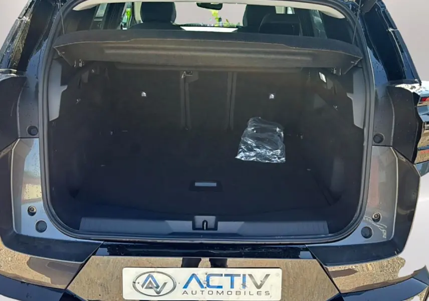 Coffre ouvert vu de l'arrière d'un Citroën C5 Aircross gris platinium avec hayon électrique et plancher de coffre mobile.