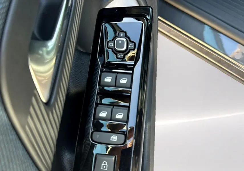 Gros plan sur les commandes de lève-vitres et rétroviseurs côté conducteur du Citroën C5 Aircross gris platinium.