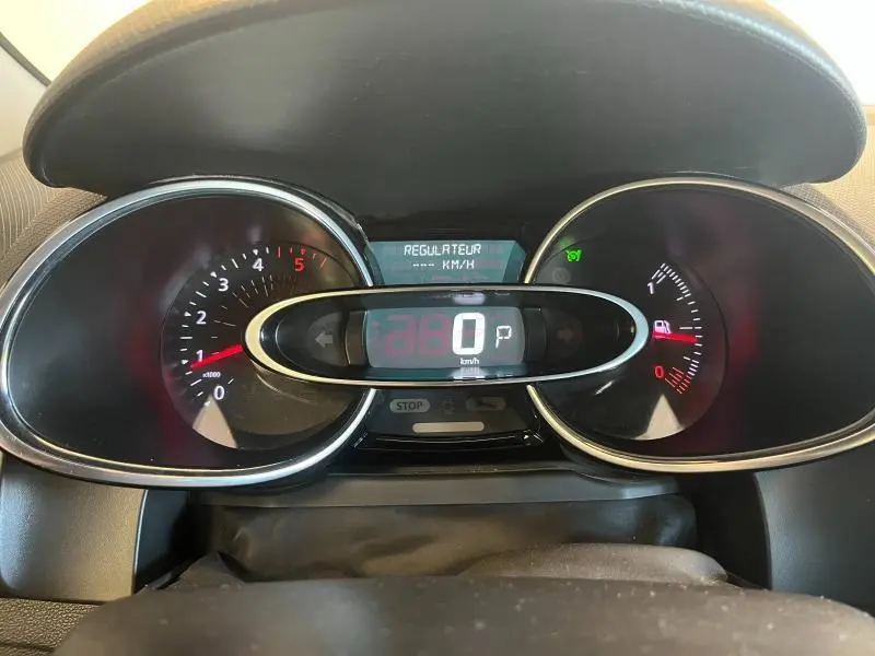 Tableau de bord de Renault Clio Estate blanc, affichage numérique au centre avec vitesse à 0 km/h et régulateur activé.
