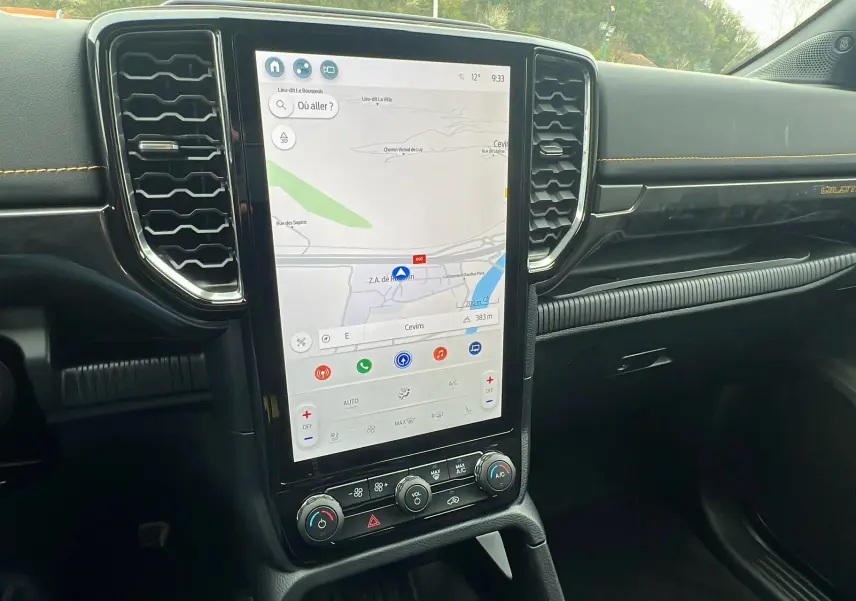 Vue intérieure du tableau de bord du Ford Ranger 2025 Wildtrak Plus avec écran tactile vertical et finitions noires et surpiqûres jaunes.