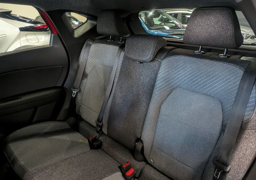 Banquette arrière en tissu gris du Renault Captur E-TECH 2025, vue intérieure côté gauche avec ceintures de sécurité visibles.