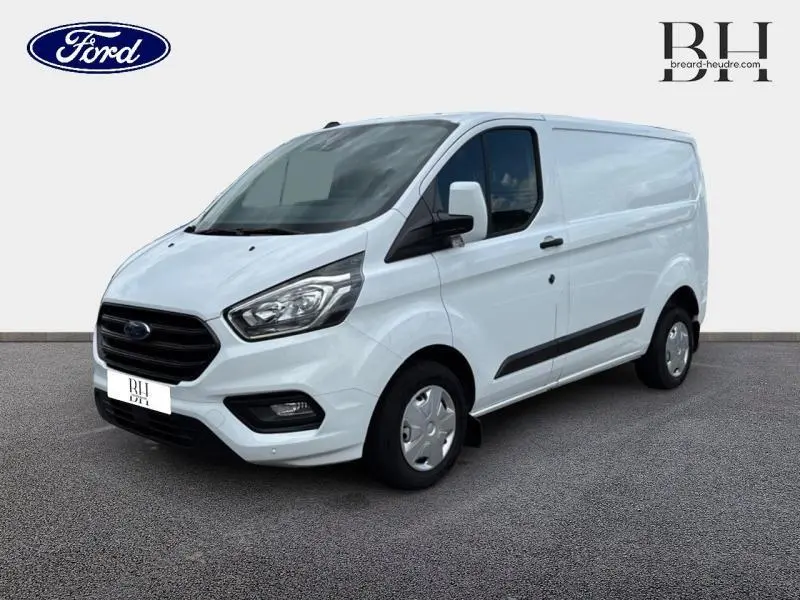 Fourgon Ford Transit Custom blanc glacier vu en 3/4 avant droit avec calandre noire et jantes acier.