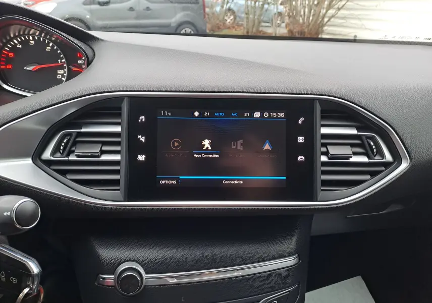 Tableau de bord noir de Peugeot 308 2019 avec écran tactile central affichant les applications connectées.