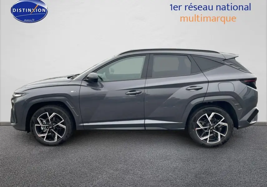 Vue de profil côté gauche du Hyundai Tucson 2025 gris écotronique avec jantes alliage 19 pouces et lignes anguleuses marquées.