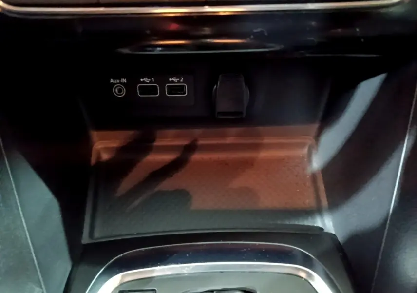 Gros plan sur la console centrale de la Renault Mégane Business gris clair, montrant les ports USB et prise auxiliaire.