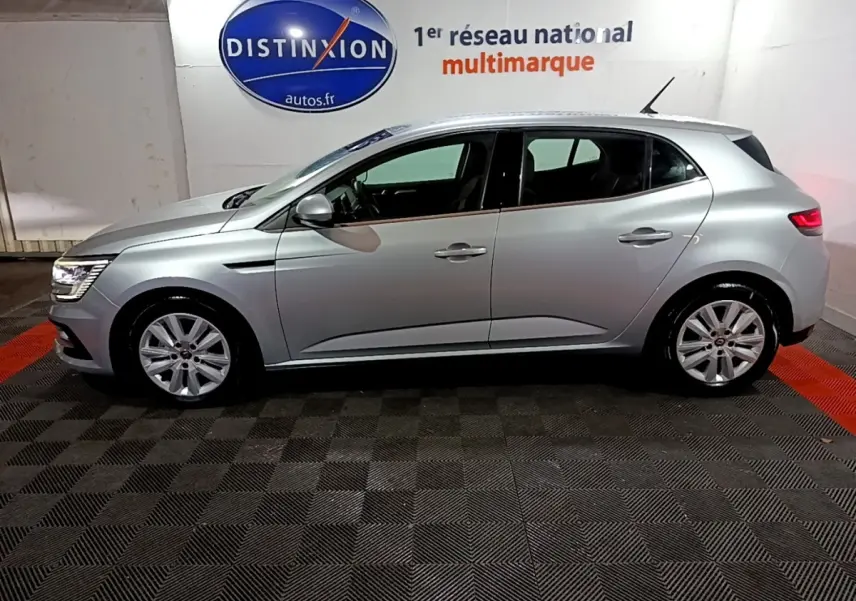 Profil droit d'une Renault Mégane Business Blue dCi 115 EDC gris clair, en intérieur sur sol à damiers noirs et rouges.