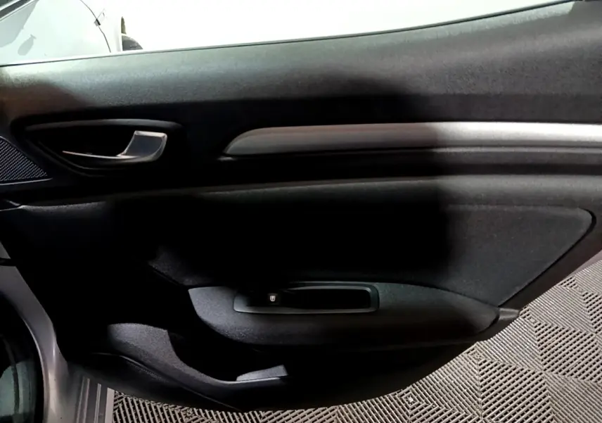 Vue intérieure côté droit de la porte avant gris clair de la Renault Mégane Business Blue dCi 115 EDC avec poignée argentée.