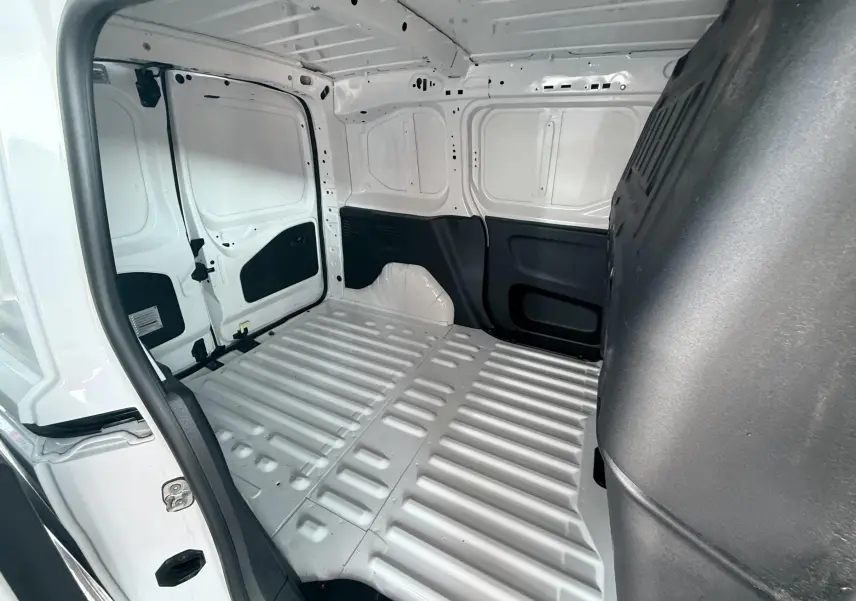 Vue intérieure de la zone de chargement arrière du Citroën Berlingo blanc 2019, version utilitaire, avec parois métalliques apparentes.