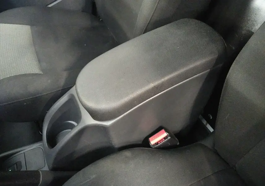 Accoudoir central et sièges avant en tissu noir dans l'habitacle du Renault Kangoo blanc 2019, version Grand Confort.