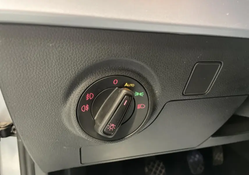Sélecteur d'éclairage avec mode automatique sur tableau de bord noir d'une SEAT Arona 2024 essence.