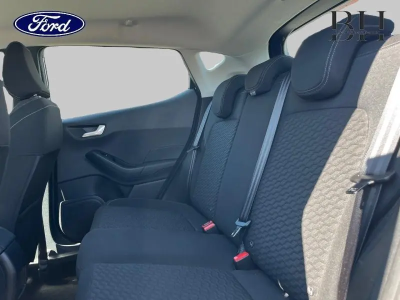 Vue latérale intérieure sur la banquette arrière noire de la Ford Fiesta 2022, avec ceinture de sécurité et appuie-têtes visibles.