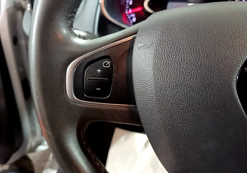Gros plan sur le volant cuir multifonctions de la Renault Clio Business gris clair de 2018, avec commandes intégrées.