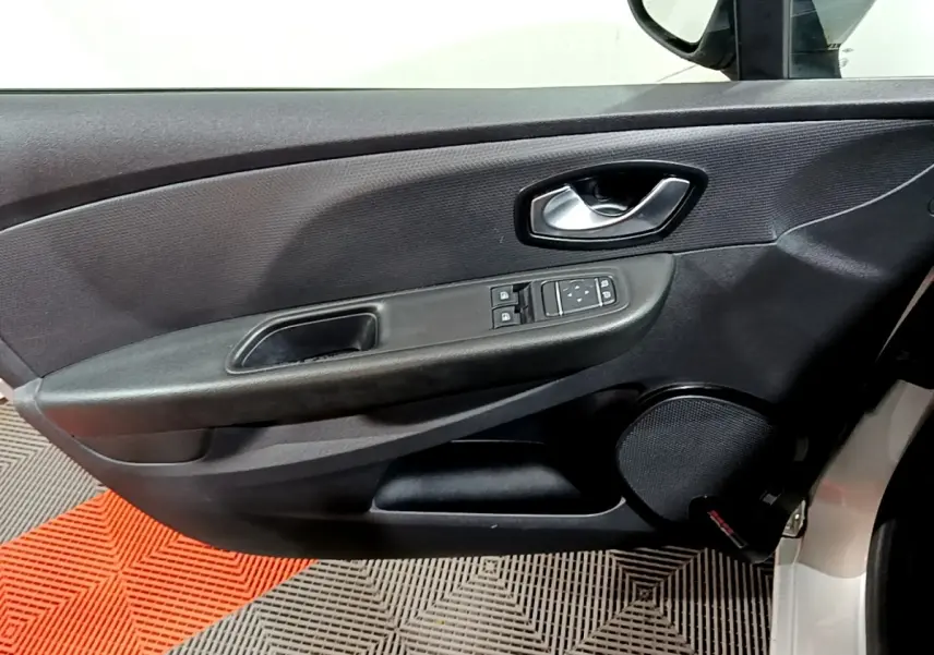 Vue intérieure du panneau de porte avant gauche gris foncé avec commandes des vitres et haut-parleur rond sur Renault Clio Business dCi 2018.