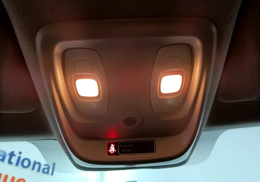 Plafonnier intérieur allumé avec témoin de ceinture passager sur Renault Clio Business gris clair, vue vers le toit avant.