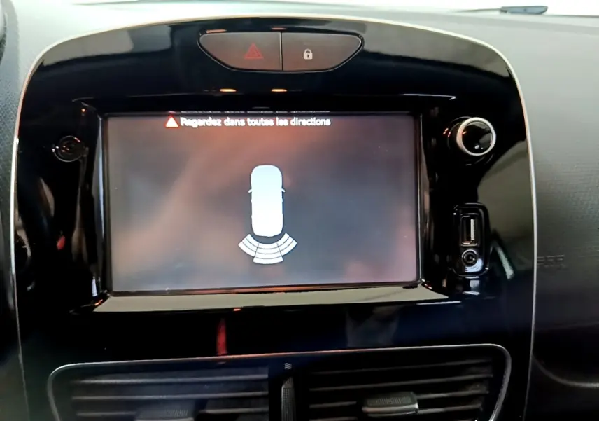 Écran tactile noir du tableau de bord de la Renault Clio Business 2018 affichant l’aide au stationnement arrière.