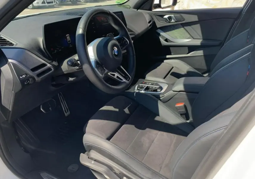 Intérieur côté conducteur de la BMW Série 1 118d 2025 avec sellerie Alcantara noire et volant M cuir multifonctions.