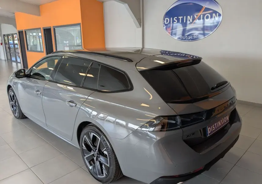 Peugeot 508 SW gris Selenium vue 3/4 arrière droit en intérieur, vitres surteintées et jantes alu 18 pouces.
