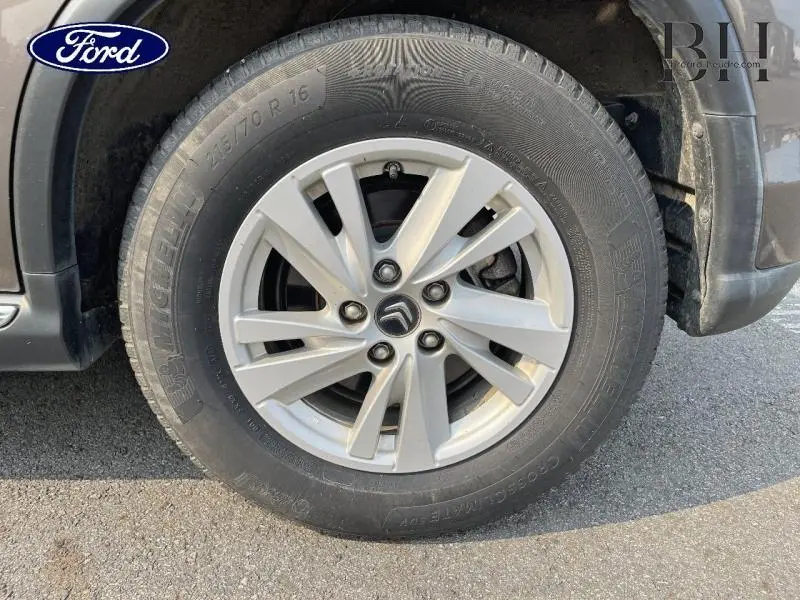 Gros plan sur la roue avant droite d'un Citroën C4 Aircross brun Mangaro avec jante alu 16 pouces et logo Citroën au centre.