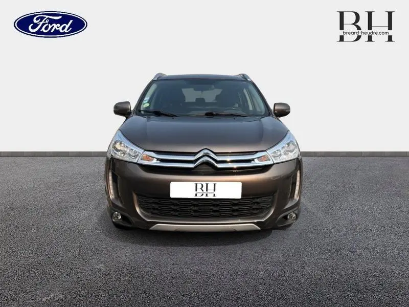 Vue frontale d'un Citroën C4 Aircross 2016 brun Mangaro avec calandre chromée et phares halogènes allumés.