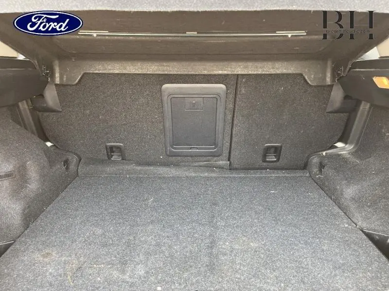 Coffre ouvert d'un Citroën C4 Aircross brun Mangaro, montrant la moquette grise et la trappe à skis centrale.