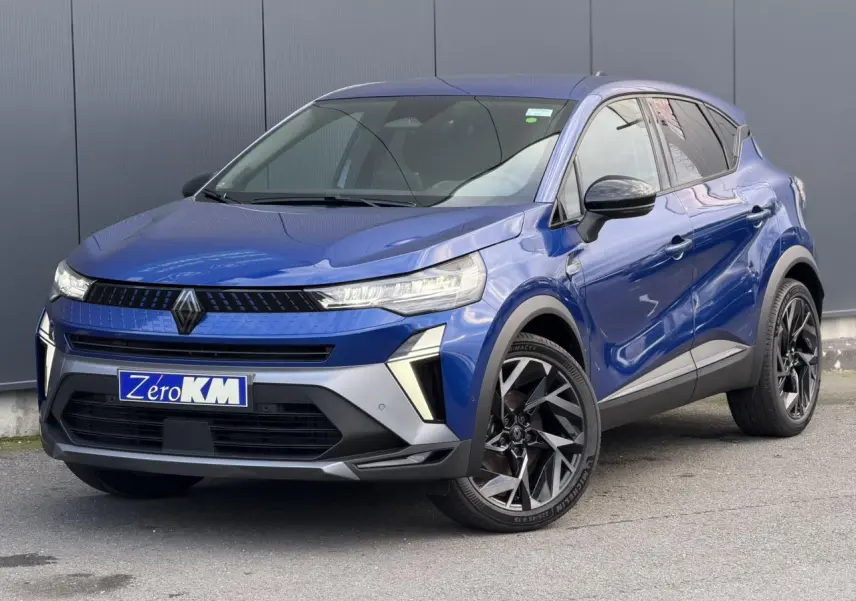 Renault Captur 2025 bleu Iron en 3/4 avant droit avec jantes aluminium noires et badge Esprit Alpine visible.