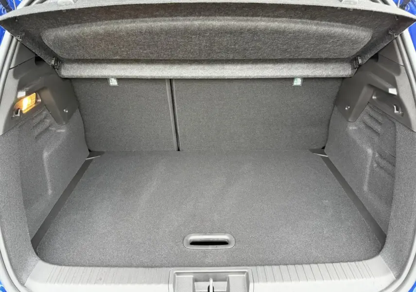 Coffre ouvert vu de l'arrière d'un Renault Captur Bleu Iron 2025, montrant l'espace de chargement vide.