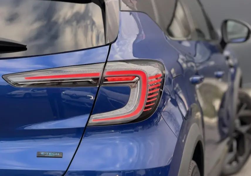 Vue arrière côté gauche du Renault Captur 2025 Bleu Iron avec feux LED distinctifs et badge E-Tech Hybrid.
