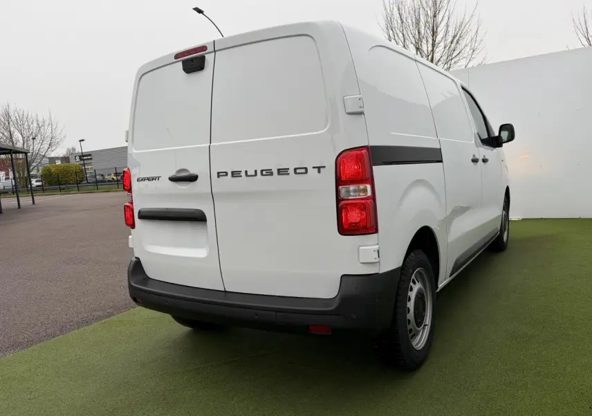 Vue 3/4 arrière droite du Peugeot Expert Fourgon blanc Icy avec jantes tôles grises et feux arrière rouges.