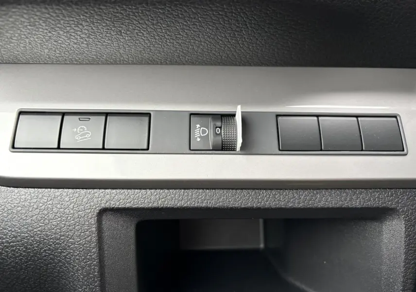 Gros plan sur les commandes de réglage des phares et de l’aide à la descente du Peugeot Expert Fourgon blanc Icy.