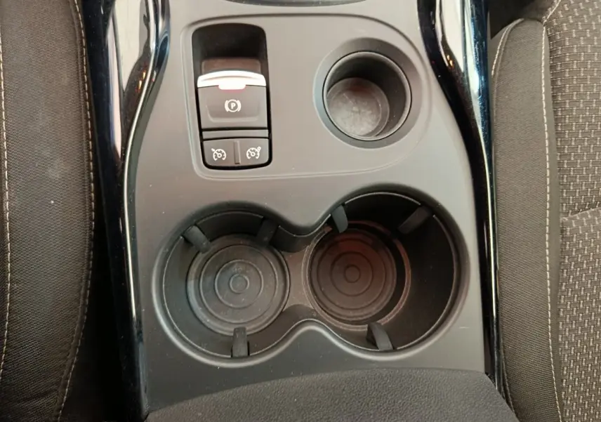 Vue rapprochée de la console centrale noire du Renault Kadjar Business Blue dCi 115 EDC avec frein à main électrique et porte-gobelets.