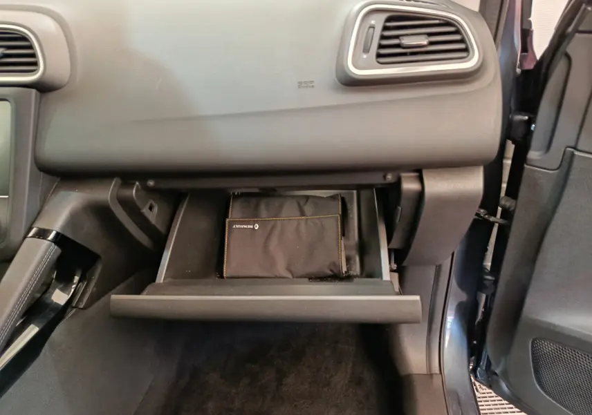 Vue intérieure du coffre à gants ouvert côté passager du Renault Kadjar Business gris foncé avec pochette noire visible.