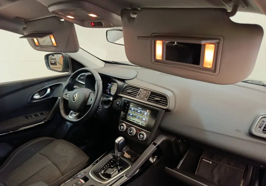 Intérieur avant droit du Renault Kadjar gris foncé 2022, tableau de bord avec écran tactile et volant multifonctions.
