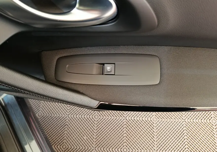 Détail de la commande de lève-vitre côté conducteur dans une Renault Kadjar gris foncé, version Business 2022.