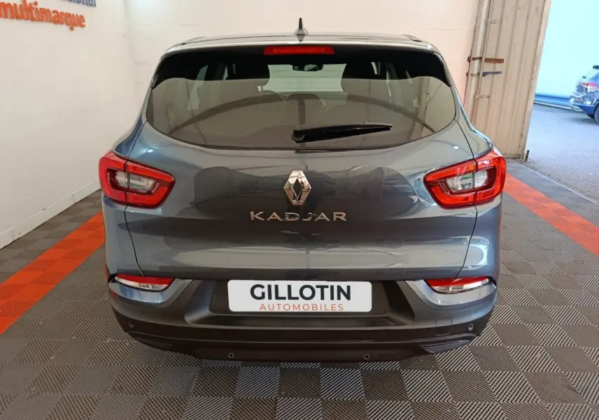 Vue arrière d'un Renault Kadjar gris foncé 2022 avec feux arrière rouges et logo central visible.