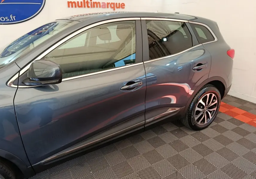 Vue latérale gauche du Renault Kadjar Business gris foncé, mettant en valeur les jantes alliage et les lignes chromées.
