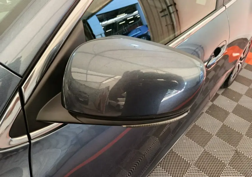 Rétroviseur côté gauche gris foncé du Renault Kadjar Business Blue dCi 115 EDC 2022 avec carrosserie visible en reflet.