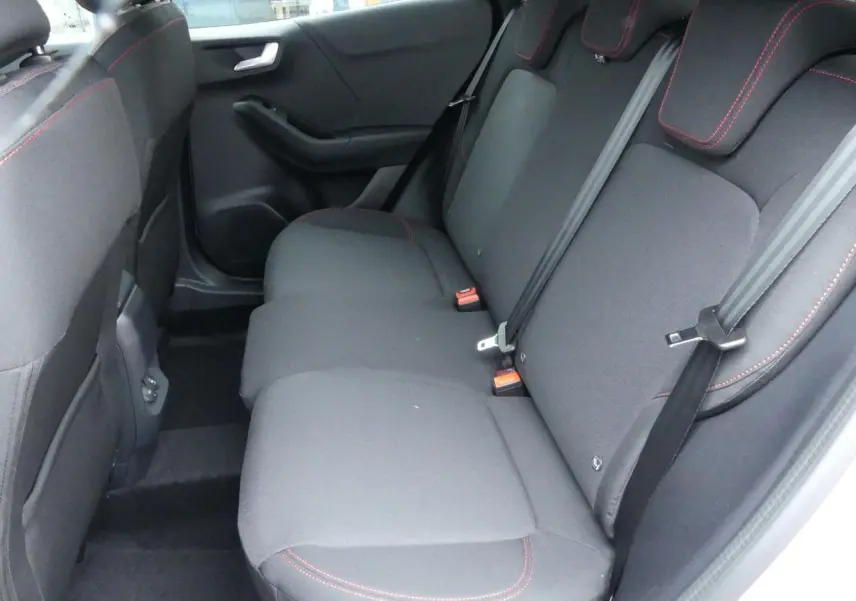 Vue intérieure arrière droite des sièges arrière noirs avec surpiqûres rouges du Ford Puma 2025 gris métallisé.