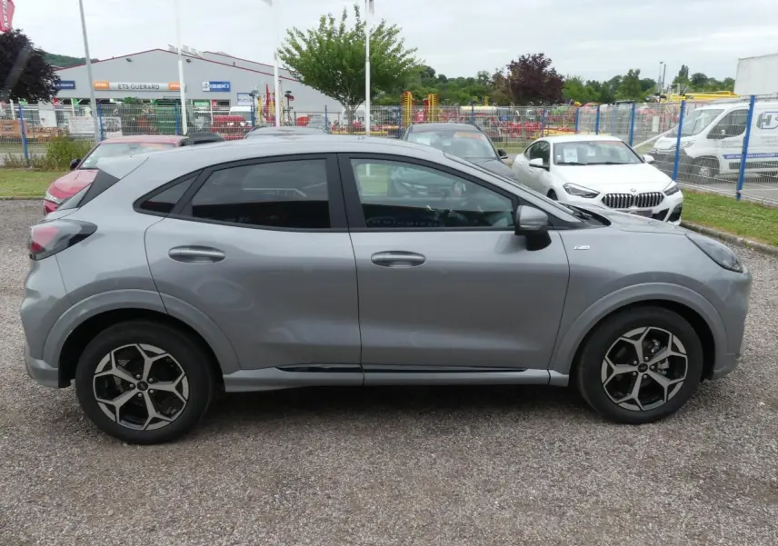 Ford Puma 2025 gris métallisé vu de profil côté gauche avec jantes alliage et vitres arrière surteintées.