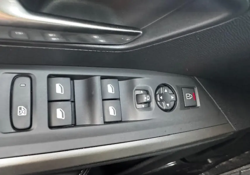 Gros plan sur les commandes des vitres et rétroviseurs côté gauche d’un Peugeot 5008 Bleu Ingaro 2025.